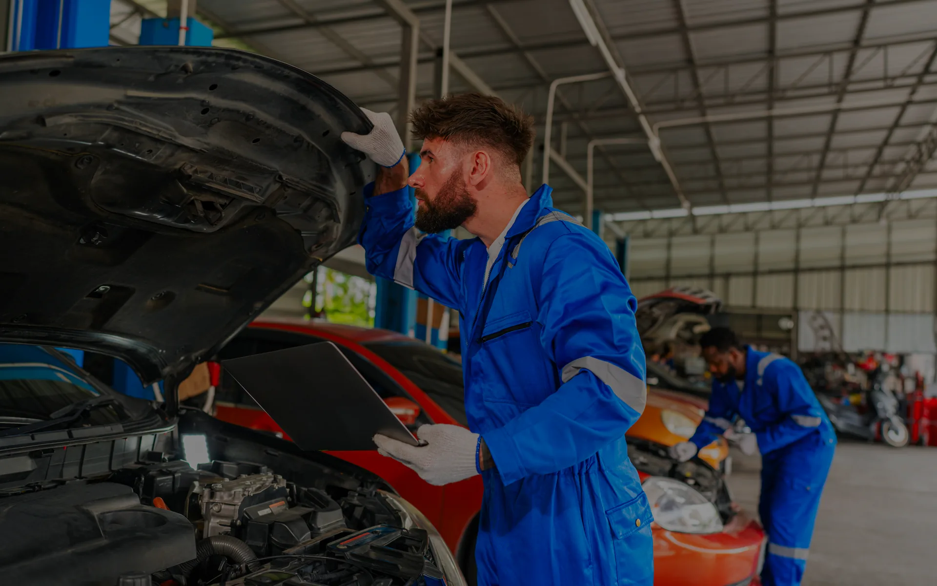 Mecánico inspeccionando el motor durante los procesos de un taller mecánico